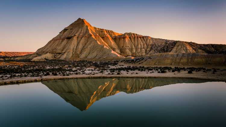 Paisaje donde se reflejan las Bardenas Reales con un gran lago.